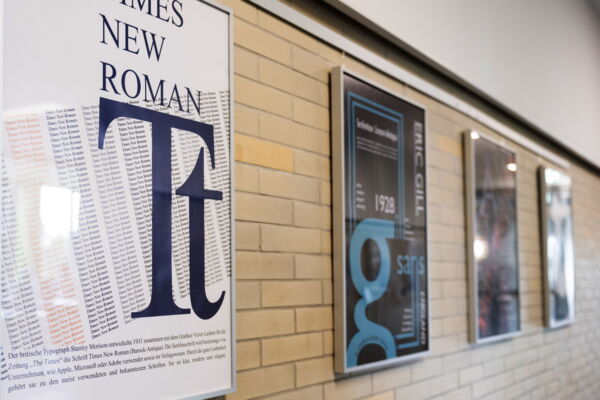 Vier Plakate im Rahmen an einer Wand hängend beschäftigen sich mit typografischen Themen.