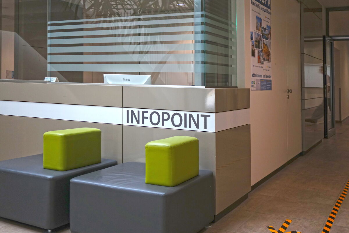 Der Flurbereich mit dem nicht besetzten Infopoint und zwei Sesseln.
