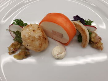 Teller mit Fischstückchen, Radieschen, Salat und Mayonaise.