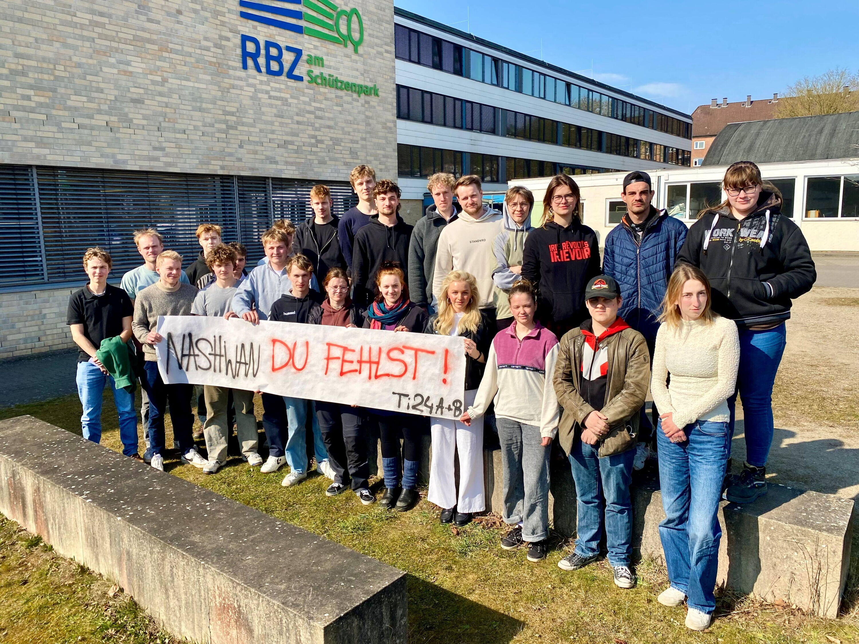 Protest gegen die Abschiebung eines Tischler-Azubi, eine ganze Klasse hält ein Protestplakat mit dem Text: »Nashwan, du fehlts uns!«