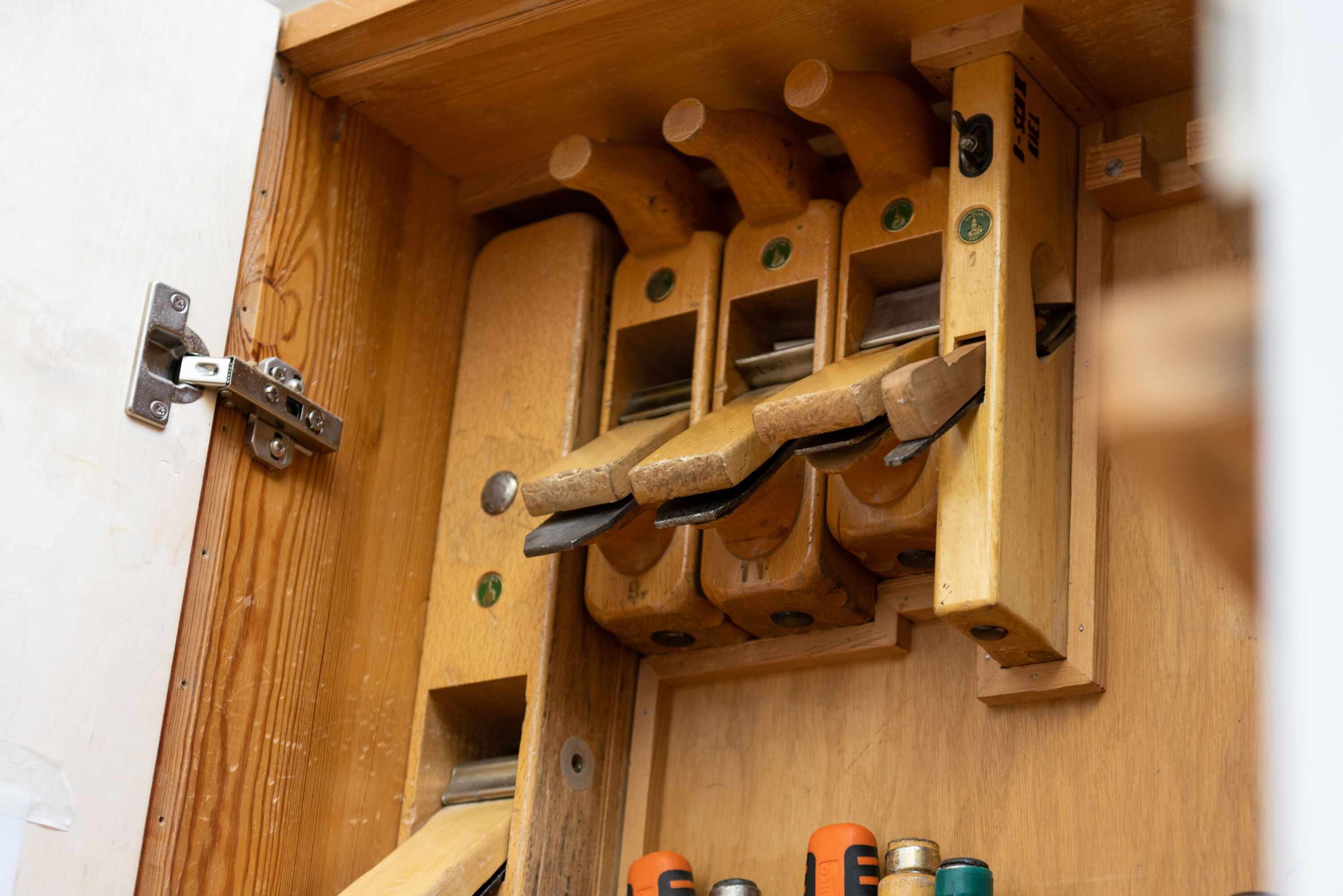 Verschiedene Handhobel in eienem Werkzeugschrank.