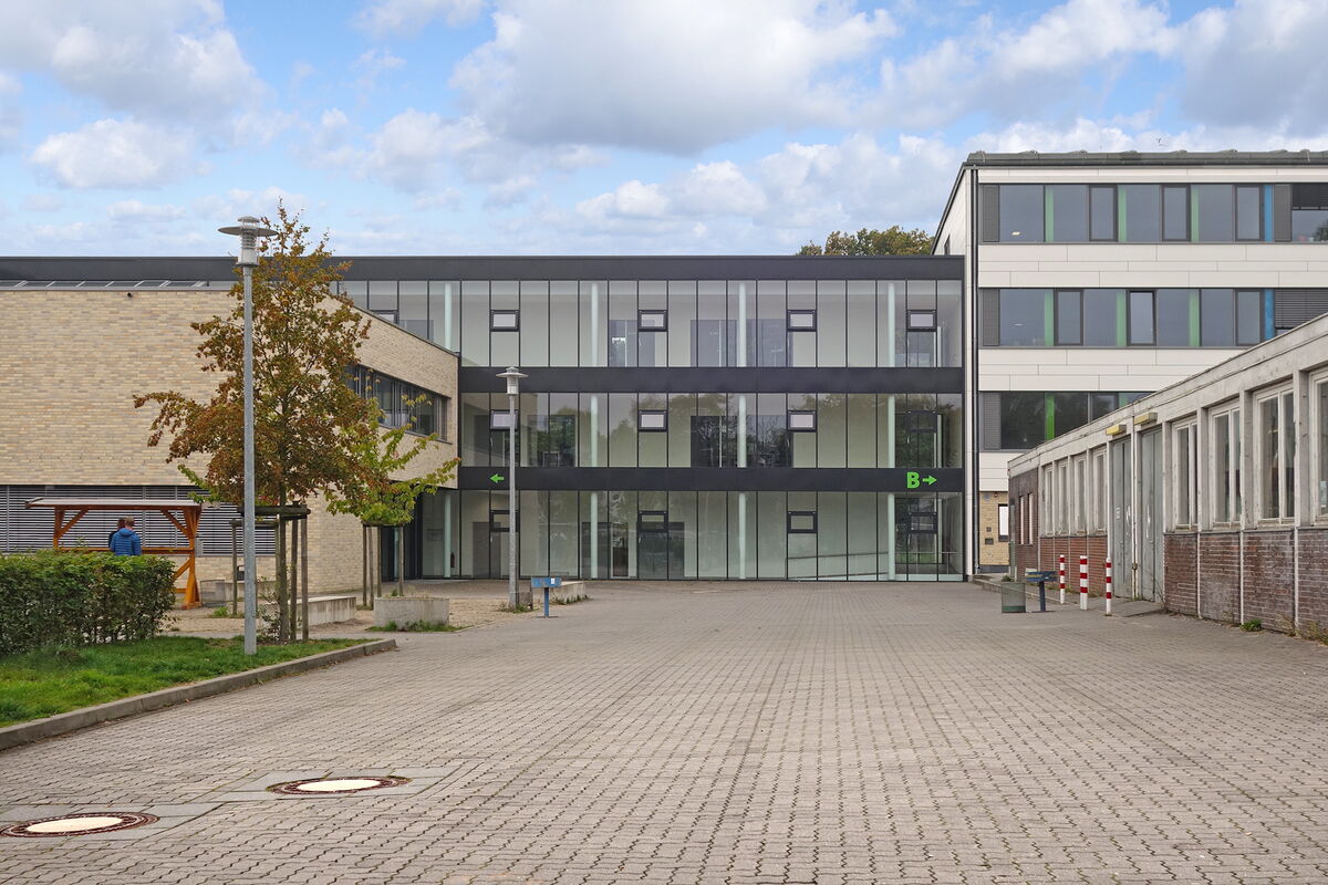 Haupteingang von der Gellertstraße, mit den Eingängen zu A und B, Pflastersteine im Vordergrund.